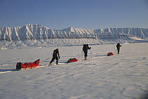 Three people skiing across snow from Ny Alesund to Longyearbyen, Spitsbergen, Svalbard, Norway