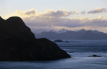 Silhouetted cape and mountains at dusk, South Georgia