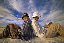Young hikers, reading and resting among sand dunes, White Sands National Park, New Mexico
