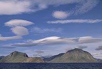 Lenticular clouds and granite mountain surrounding Eclipse Harbor and Torngat Mountain, site of proposed national park, summer, Labrador Sea, Newfoundland, Canada