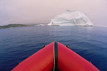 View from bow of red rubber boat heading toward floating iceberg in summer, Labrador Sea, Labrador, Canada