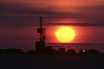 Prudhoe Bay oil fields on Beaufort Sea in evening, setting sun, North Slope, Alaska