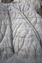 Close-up of intricate patterns of eroded sandstone cliffs in a small canyon near Churchwells, noon, Utah