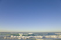 Gentle sea waves rolling on sandy St. Kilda Beach in soft morning light, winter, Dunedin, Otago, South Island, New Zealand