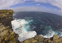 Rocky seashore, steep cliffs with colorful lichens, Beaver Island, Falkland Islands