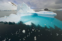Blue and green iceberg, with base sculpted by waves and melting of ice, Gerlache Passage, Antarctica