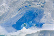 Iceberg with dark blue lines created by water which entered glacial crevices and froze there, western Antarctica