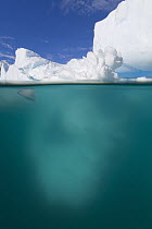 Iceberg sculpted by waves, floating in calm sea, western Antarctica