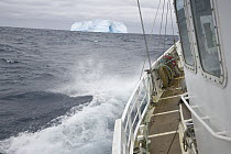 Sailboat approaching blue iceberg, near South Georgia Island