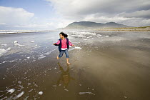 Nine year old Vira Halim-Rotinsulu running on the beach, Oregon