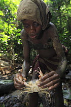 Baka girl with crab caught by drilling the bank around the burrow, Cameroon