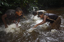 Baka woman performing a dance by splashing the water after returning from gathering fruit, Cameroon