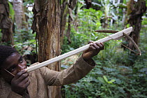 Baka boy making toy crossbow, Cameroon