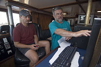Blue Whale (Balaenoptera musculus) researchers, Bruce Mate at right, looking at tracking data, Costa Rica