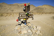 Teakettle Junction post decorated with kettles by tourists, Death Valley National Park, California