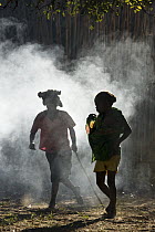 Malagasy girls walking in a smoky area, Bekopaka, western Madagascar