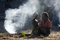 Malagasy girls doing each others hair in smoky area, Bekopaka, western Madagascar