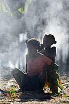 Malagasy girls doing each others hair in smoky area, Bekopaka, western Madagascar