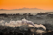 Winter dawn over industrial chimneys with Seaward Kaikoura Range behind, Christchurch, New Zealand