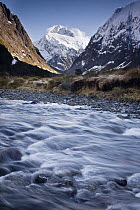 Mount Talbot under winter snow and Hollyford River near Homer Tunnel, Fiordland National Park, New Zealand