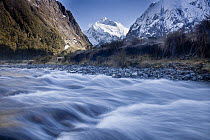 Mount Talbot under winter snow and Hollyford River near Homer Tunnel, Fiordland National Park, New Zealand