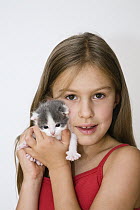 Domestic Cat (Felis catus) kitten with young girl, Germany