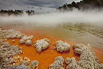 Rain storm approaches Champagne Pool, volcanic lake has constant 74 degree Celsius water including minerals gold, silver mercury, sulphur, and arsenic, Wai-O-Tapu Thermal Wonderland, Rotorua, North Is...