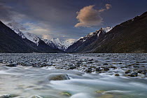Mathias River at dusk with snow-covered peaks of Southern Alps beyond, Canterbury, New Zealand