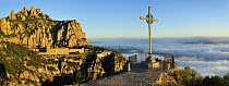 Cross on overlook with Montserrat Basilica in the background, Montserrat Natural Park, Catalonia, Barcelona, Spain