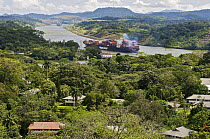 Panama Canal with container ships next to townsite, Gamboa, Panama