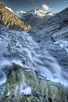 Cascade Saddle stream flows over edge into Matukituki Valley, Mount Aspiring in distance, Mount Aspiring National Park, New Zealand