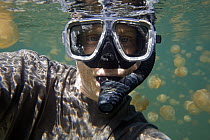 Photographer Ingo Arndt with Jellyfish (Mastigias sp) mass, Jellyfish Lake, Palau