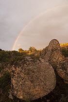 Rainbow over boulders in the Sierra Morena, Sierra de Andujar Natural Park, Andalusia, Spain