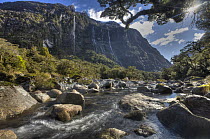 Cleddau River with waterfalls streaming off rock face, Milford Sound, Fjordland National Park, New Zealand