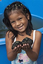 South American River Turtle (Podocnemis expansa) young held by girl, part of reintroduction to the wild program, Orinoco River, Apure, Venezuela