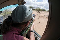 African Wild Dog (Lycaon pictus) researcher Rosie Woodruff shooting dart to tranquilize and collar an animal, Mpala Research Centre, Kenya