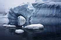 Iceberg with arch and ice floes, Antarctica