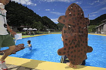 Japanese Giant Salamander (Andrias japonicus) costume for swimming race for kids at the salamander festival in Yubara, Honshu, Japan