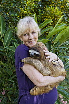 Brown-throated Three-toed Sloth (Bradypus variegatus) held by sanctuary owner Judy Avey-Arroyo, Aviarios Sloth Sanctuary, Costa Rica