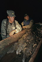 Game wardens with confiscated boat full of iguanas that were poached for sale as bush meat, Barro Colorado Island, Panama