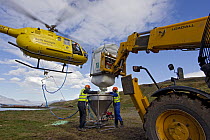 Helicopter bucket being filled with bait for South Georgia Heritage Trust Rat Eradication Project, Grytviken, South Georgia Island