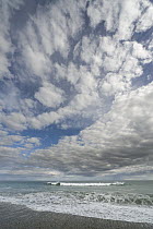 Cumulus clouds above waves, Gillespie's Beach, South Island, New Zealand