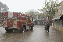 Firemen talking to shop owners during flood, Capitola, Monterey Bay, California