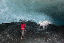 Hiker in ice cave in Mendenhall Glacier, Tongass National Forest, Juneau, Alaska