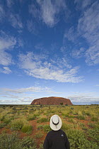 Tourist watching clouds over Ayers Rock, Uluru-kata Tjuta National Park, Northern Territory, Australia
