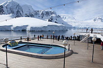 Passengers gather on the deck of the MV Amsterdam to view the stunning scenery of the Lemaire Channel, Palmer Station, Antarctic Peninsula, Antarctica