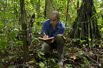 Researcher Diego Mosquera recording data from camera traps used to study large mammals, Yasuni National Park, Amazon, Ecuador