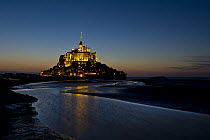 Mont Saint-Michel at sunset with water in surrounding bay, Normandy, France