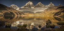 Siula Grande, Yerupaja, Yerupaja Chico and Jirishanca peaks emerge from morning cloud with reflections in Carhuacocha Lake, Cordillera Huayhuash, Andes, Peru