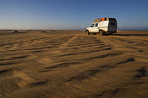 Car on sand dunes north of Moewe Bay, Namib Desert, Namibia